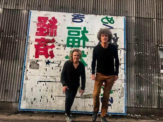 Heringa和van kalsheek站在一堵满艺术涂鸦的大墙上